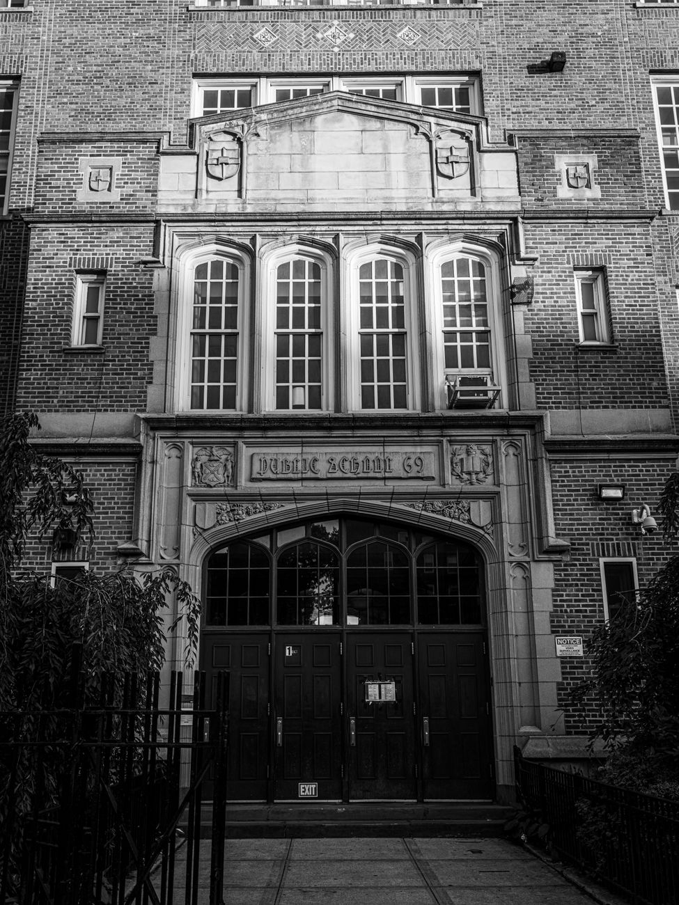 Black and white image of a historic public school facade in New York City.