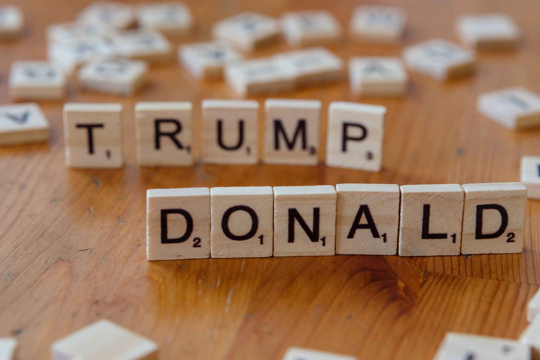 Close up of Scrabble tiles spelling &amp;#39;Donald Trump&amp;#39; on a wooden table.